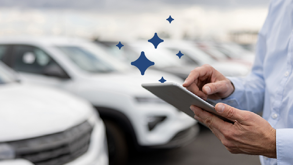 A row of parked cars with person standing in front of them using a tablet