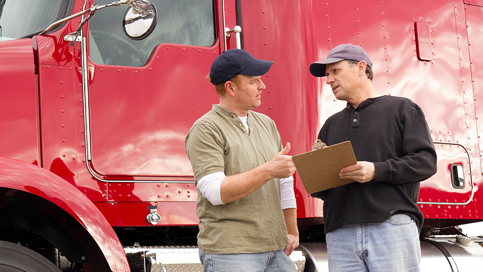 two people standing infront of a red truck