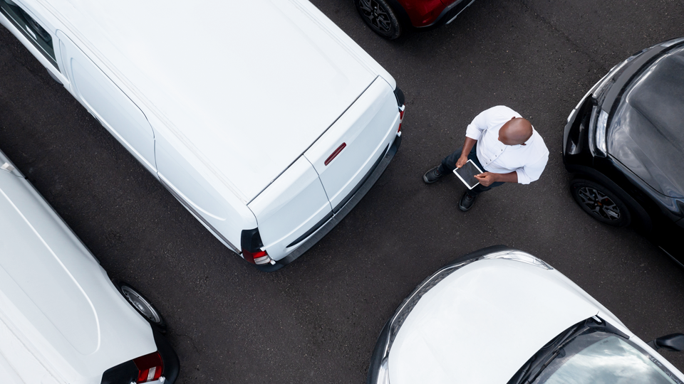 top view of a person standing in between a bunch of parked white vans