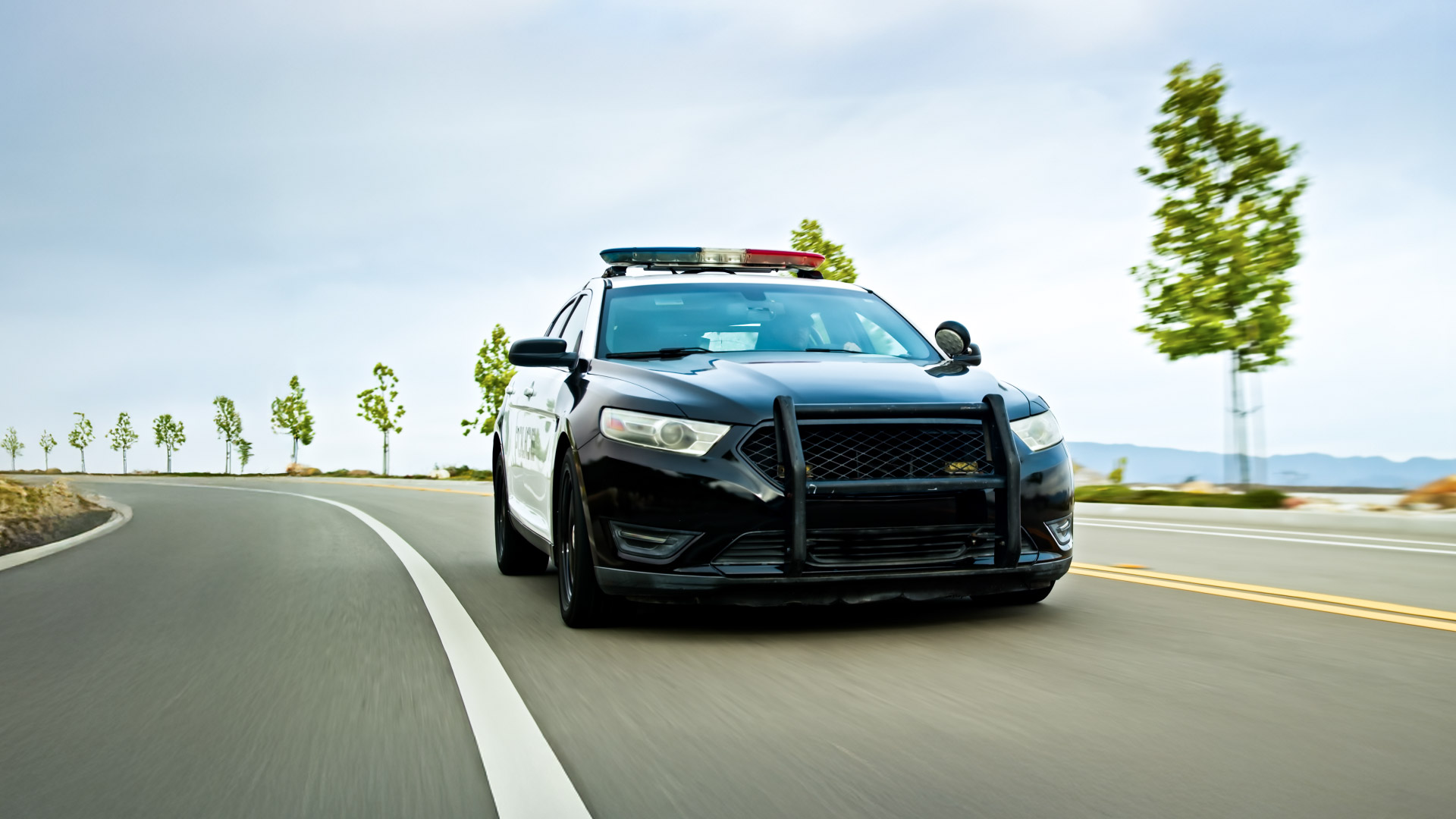 front view of a police car driving on the road