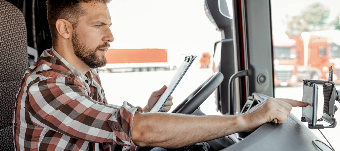 A photo of a fleet driver using a vehicle monitoring system during a trip.