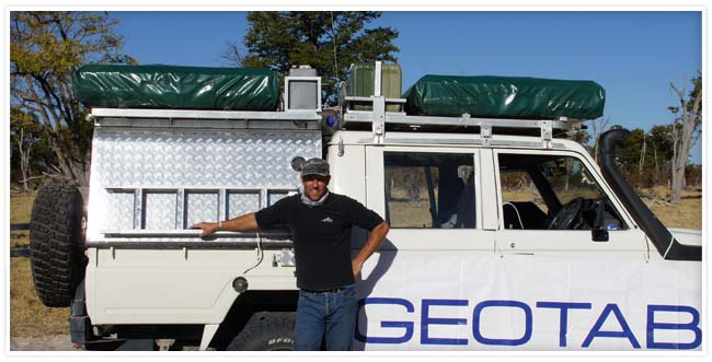 Man standing in front of a white vehicle with the a Geotab banner
