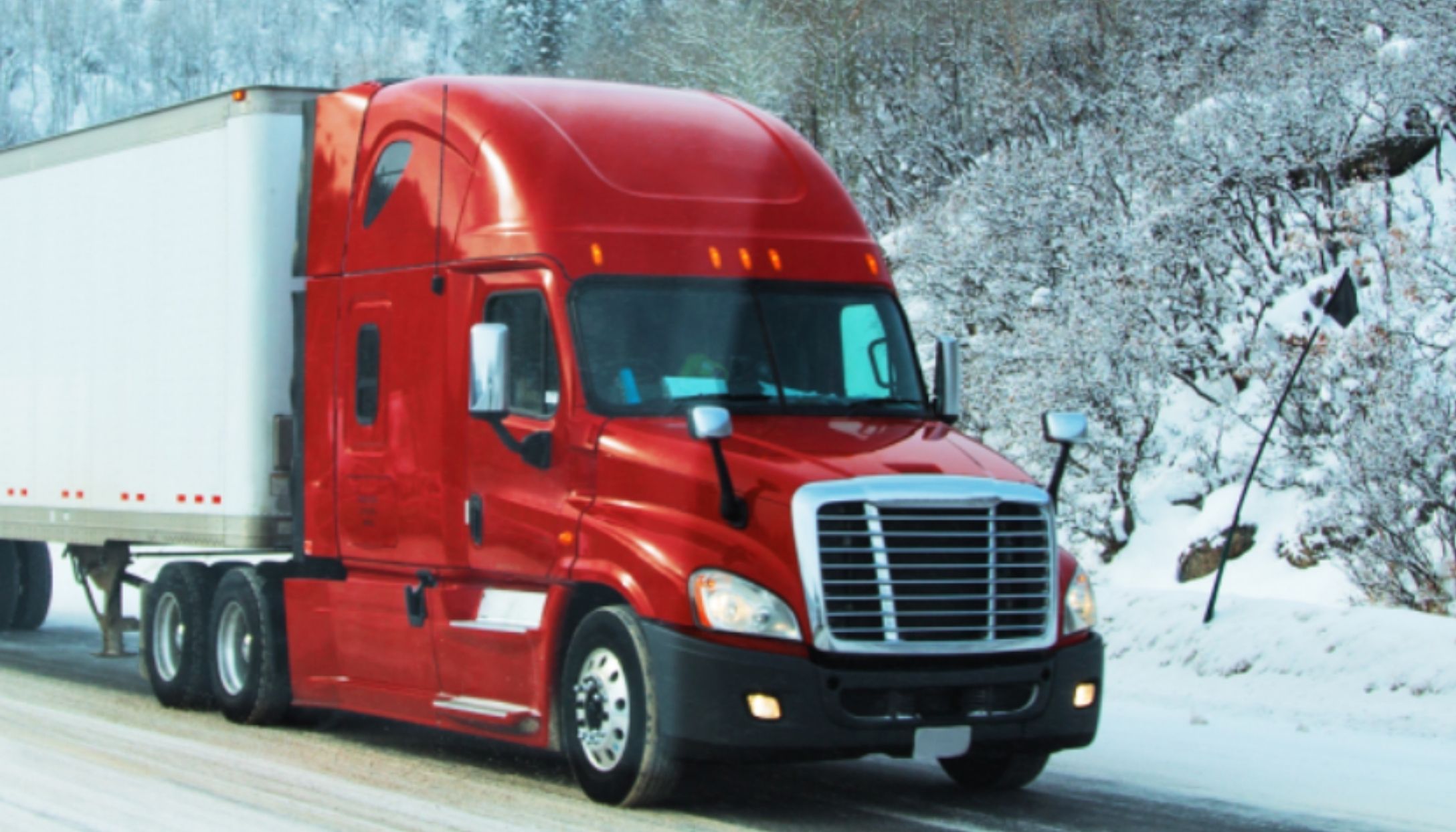 Red truck driving in the snow