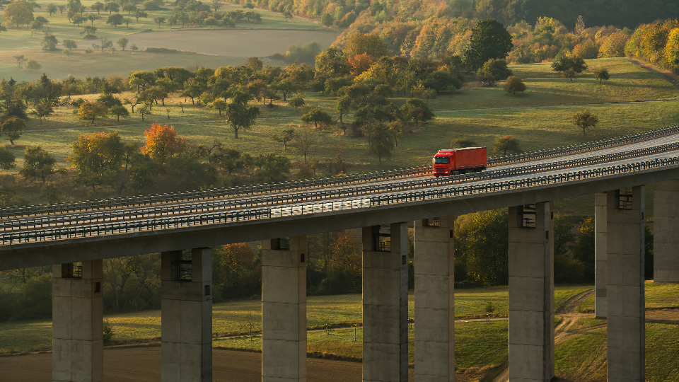 Ein Lkw fährt über einer Brücke.