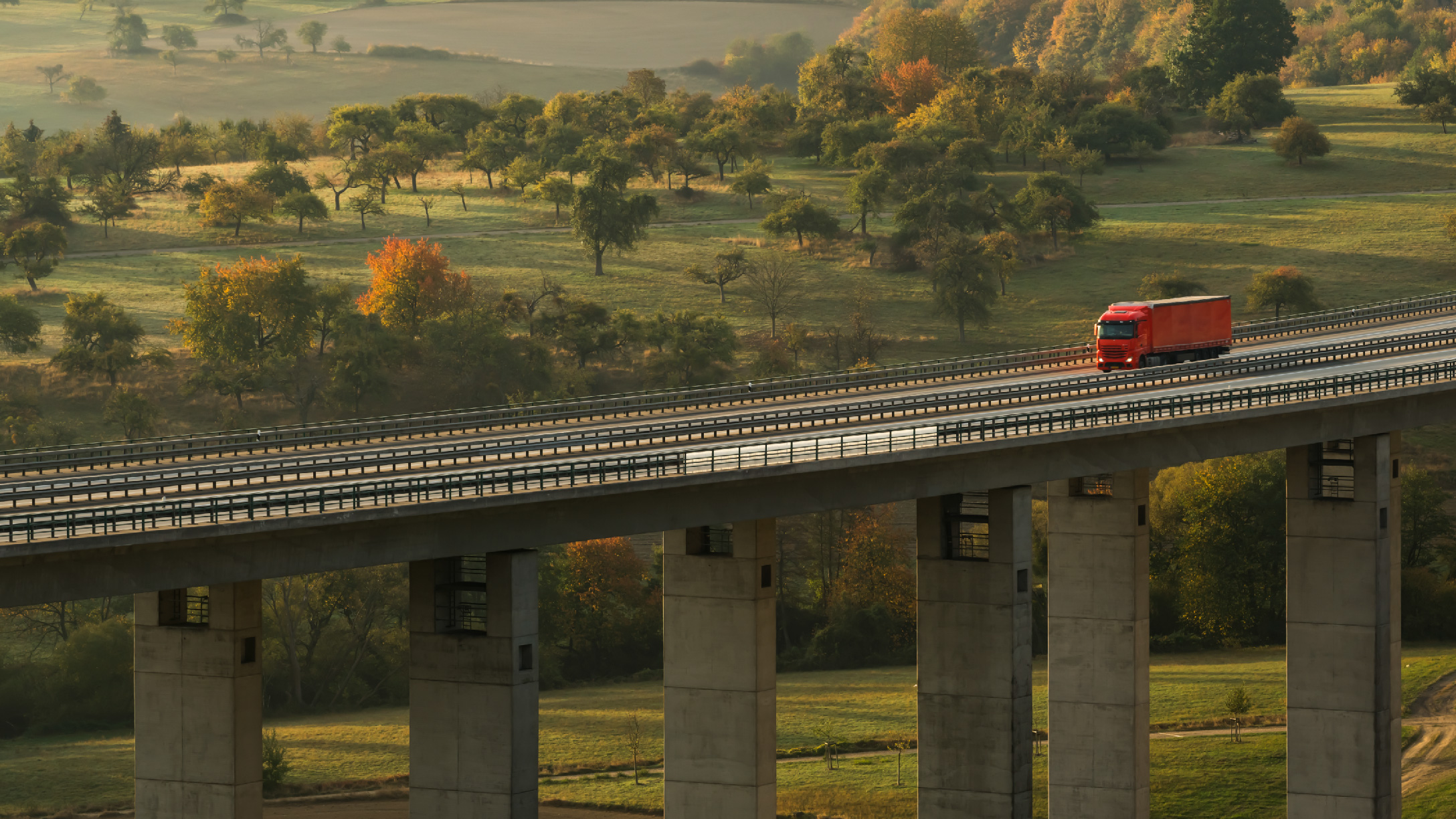 Ein Lkw fährt über einer Brücke.