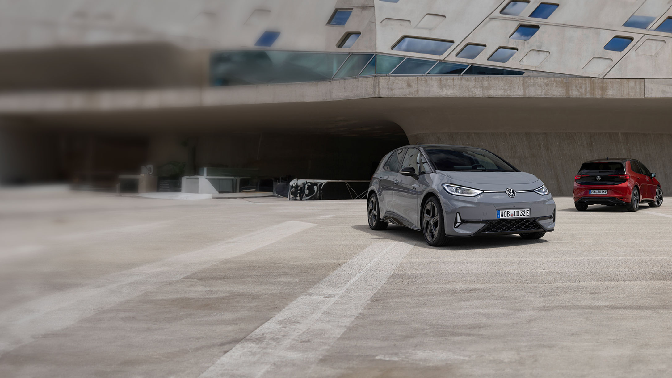 Zwei Elektrofahrzeuge von Volkswagen, die auf einem Parkplatz geparkt sind.