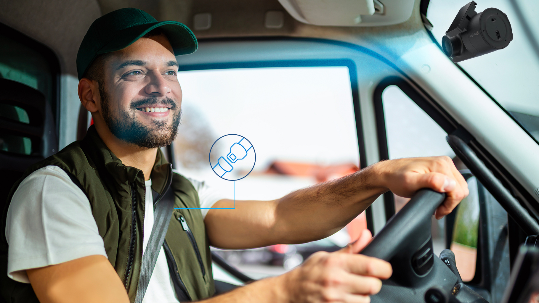 Un conductor sonriente con cinturón de seguridad puesto, manejando un vehículo comercial equipado con una cámara de video telemática instalada en el parabrisas, destacando las tecnologías avanzadas para mejorar la seguridad del conductor.