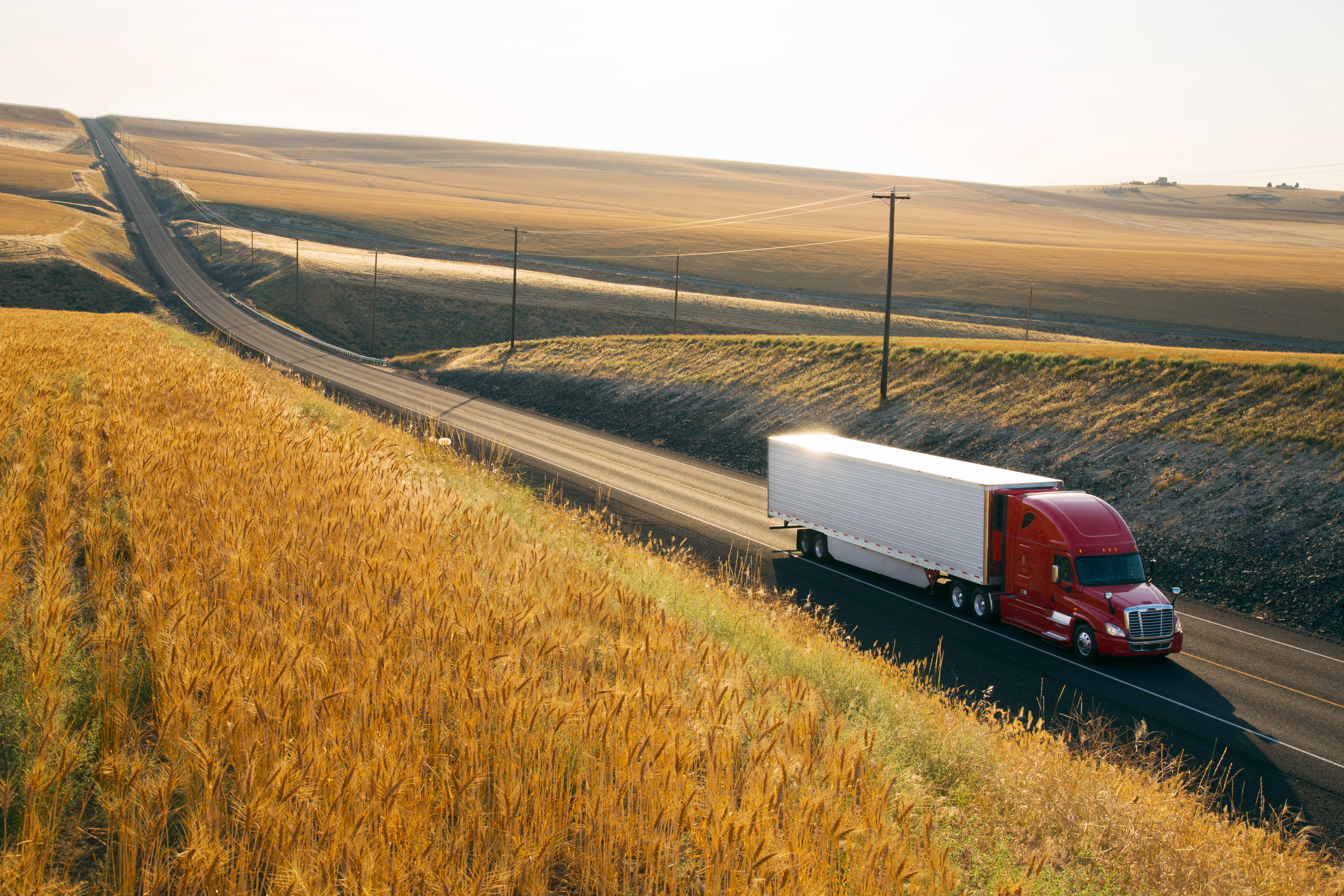 red truck driving in a countryside road