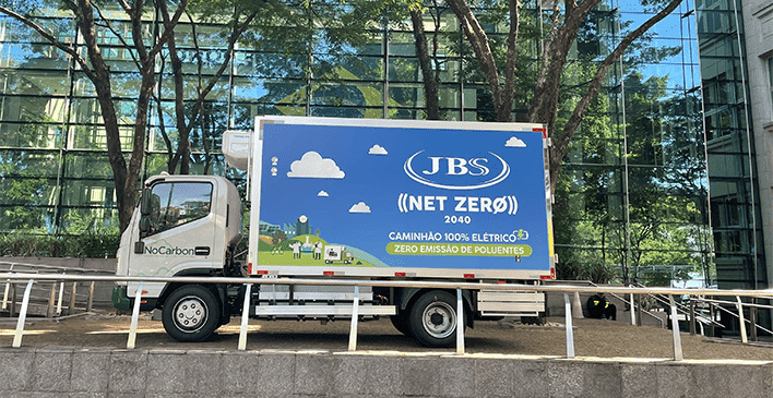 Um caminhao com a carroceria com um banner sobre net zero
