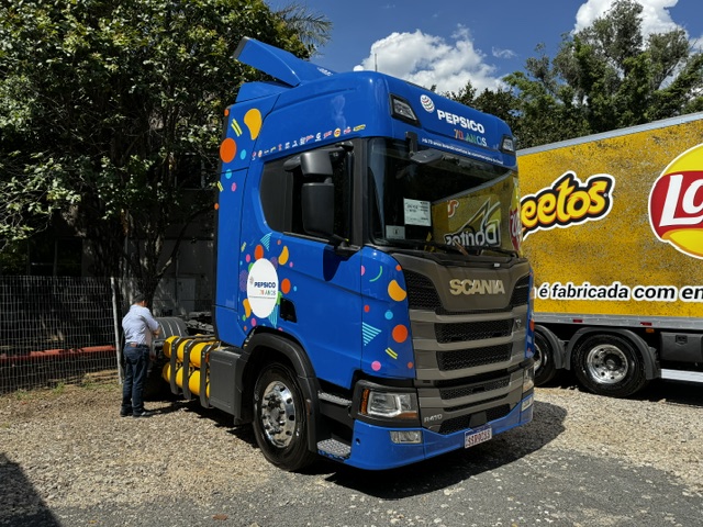 caminhão azul da pepsico estacionado e sendo inspecionado