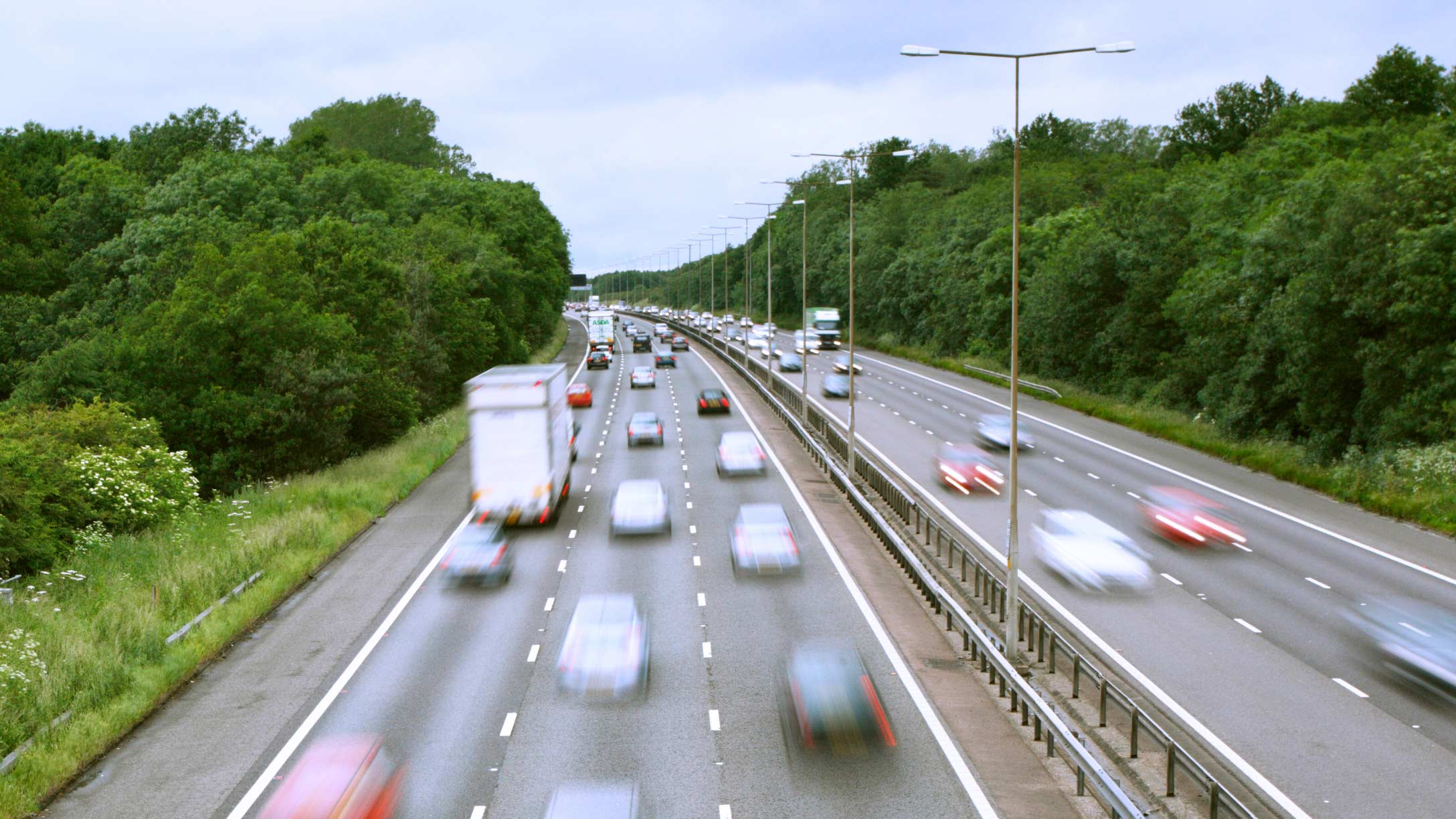 Muitos carros e caminhões em movimento nas rodovias