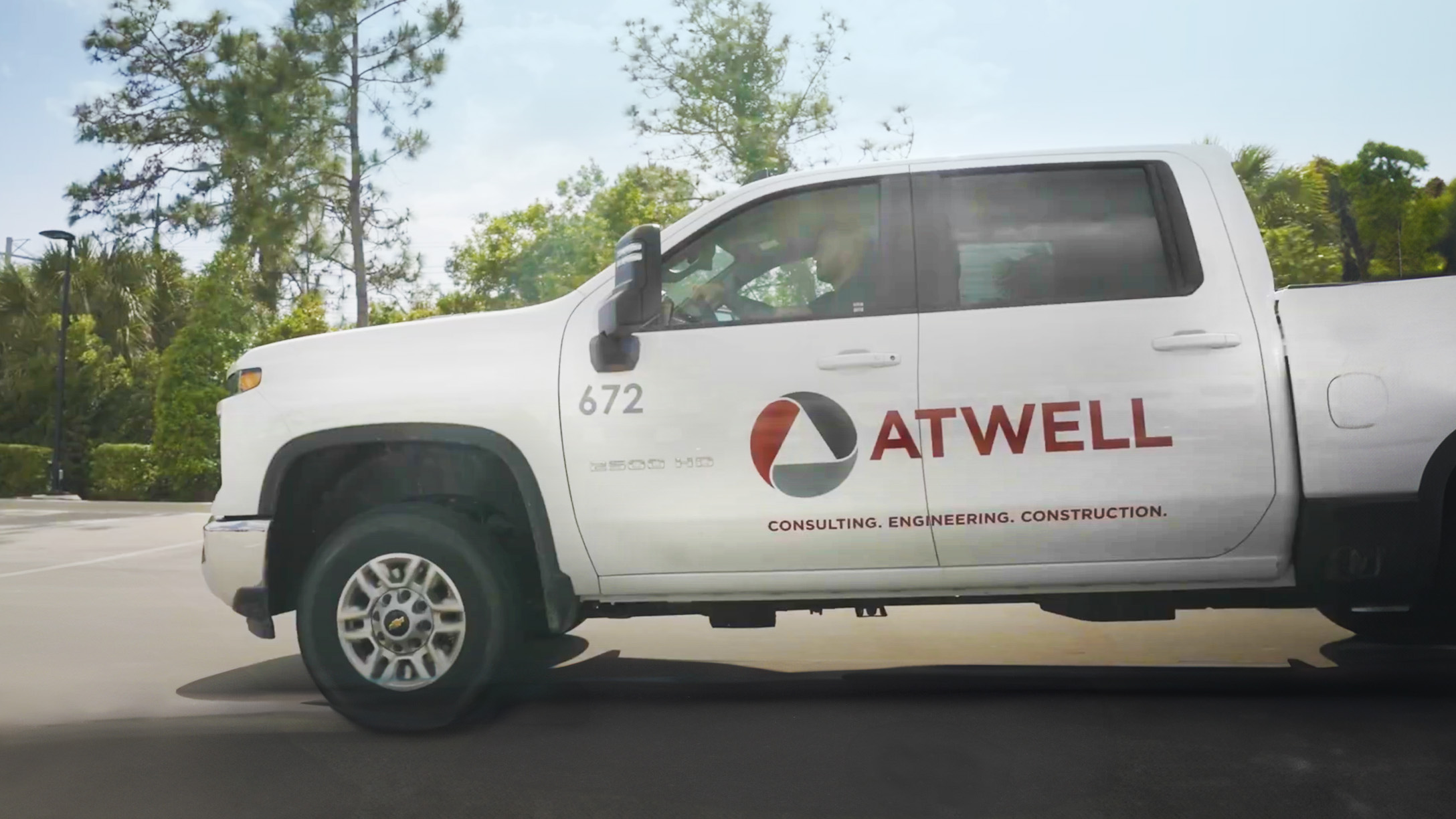 Side view image of a pick up truck with atwell group branding