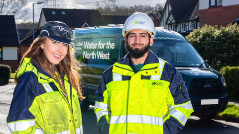 United Utilities branded vehicle, with two drivers standing in front of it.