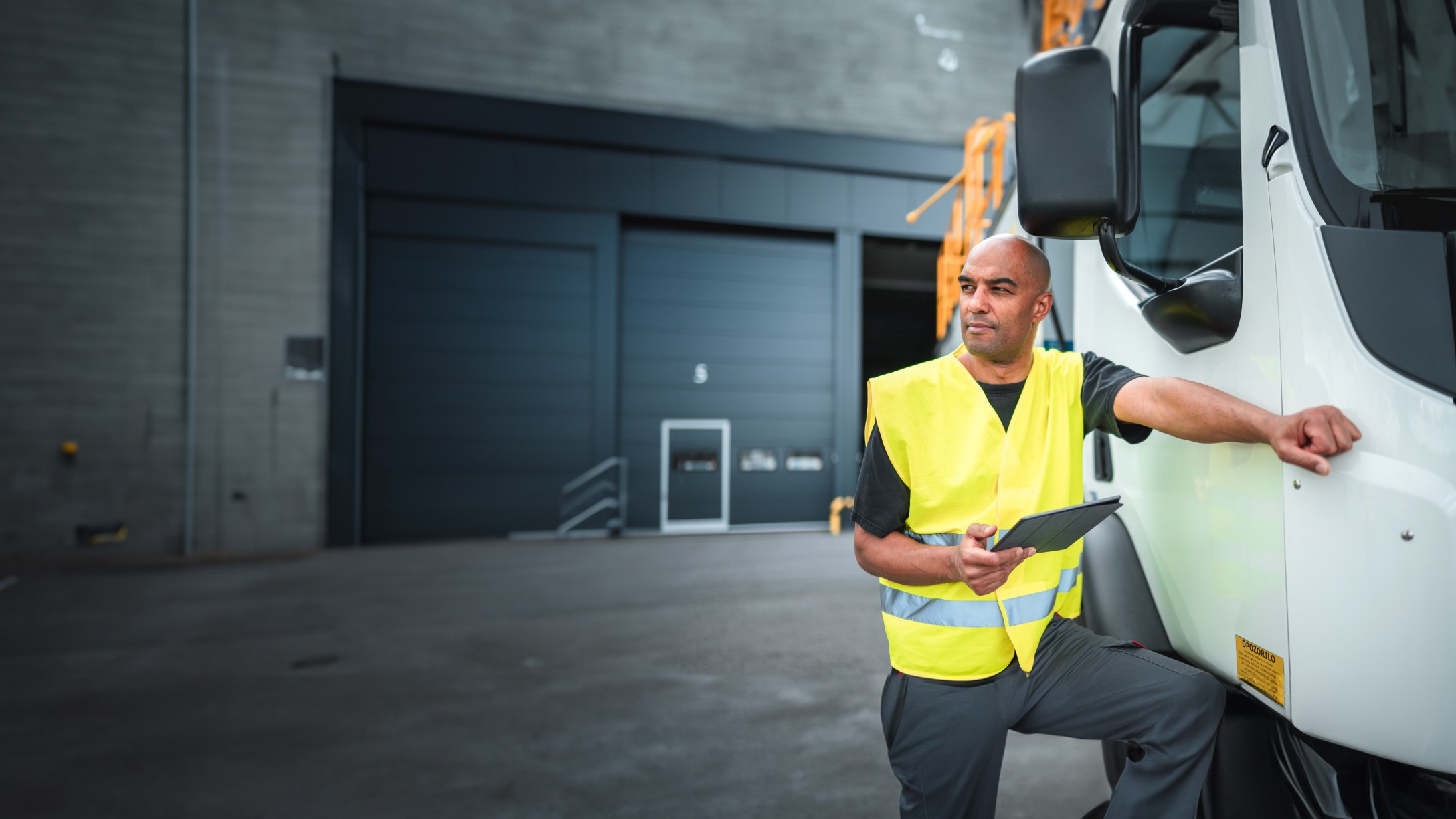 person standing next to truck holding a tablet